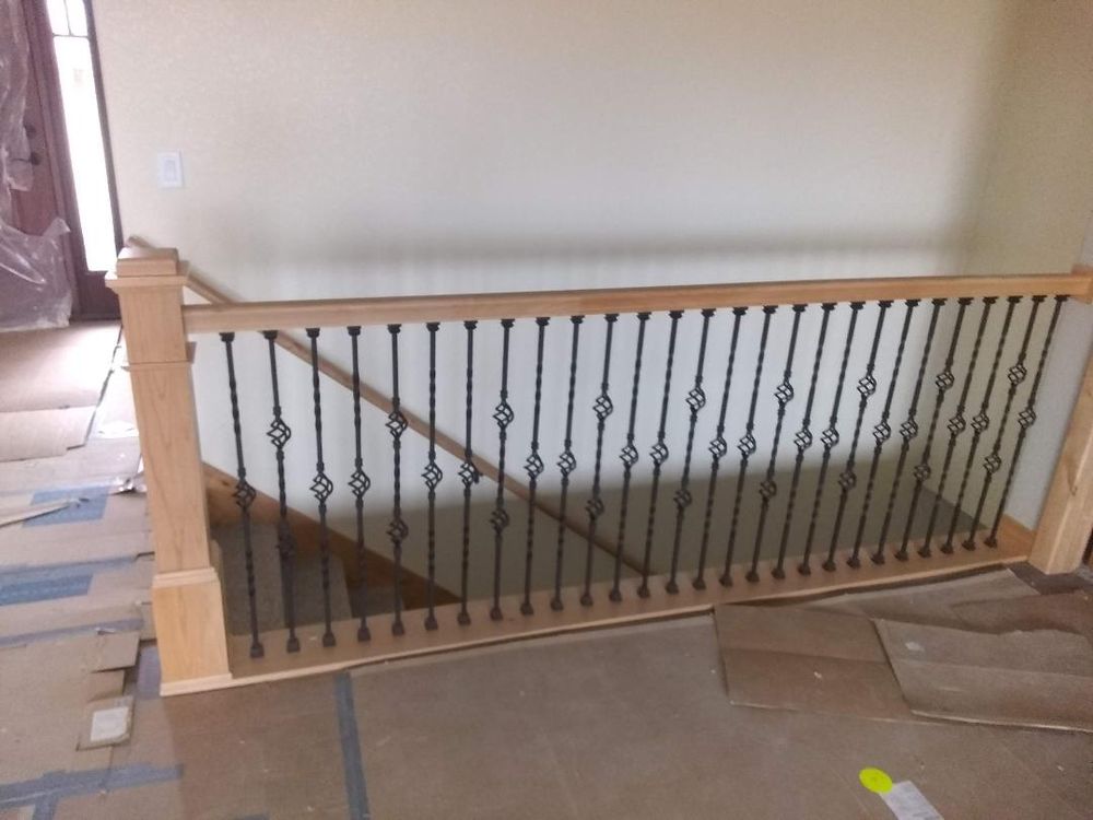 Stair overlook with iron balusters and a finished wood handrail